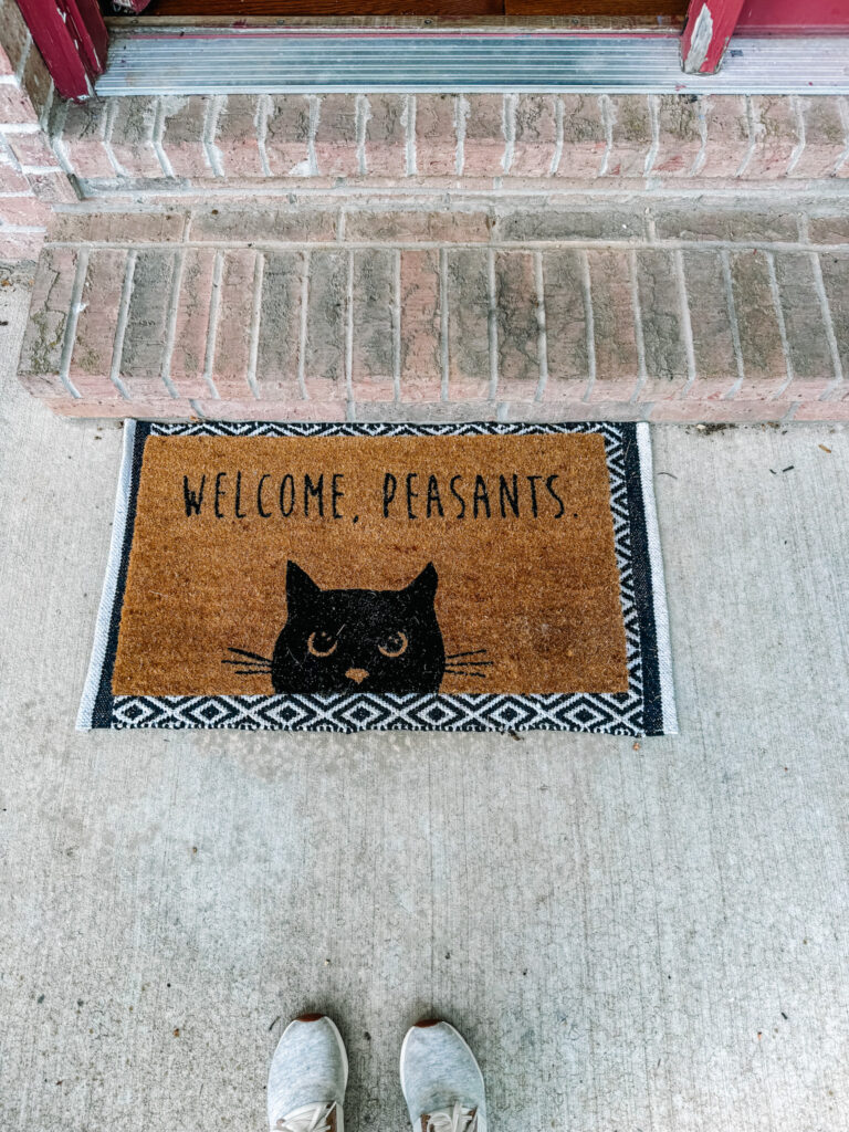 welcome peasants mat on front porch