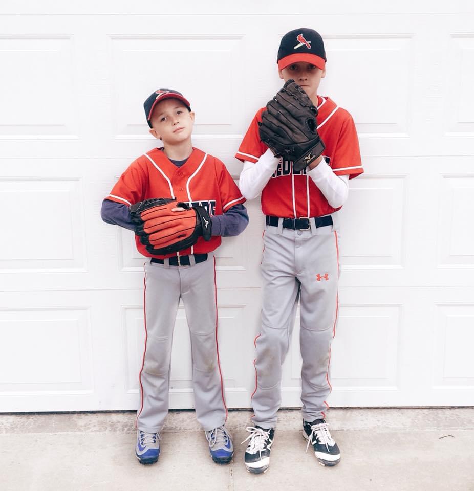 two kids holding baseball gloves